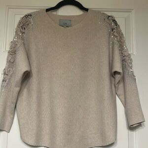 Dressy sweater cream colored 3/4 sleeves with sheer arm with beautiful accents.
